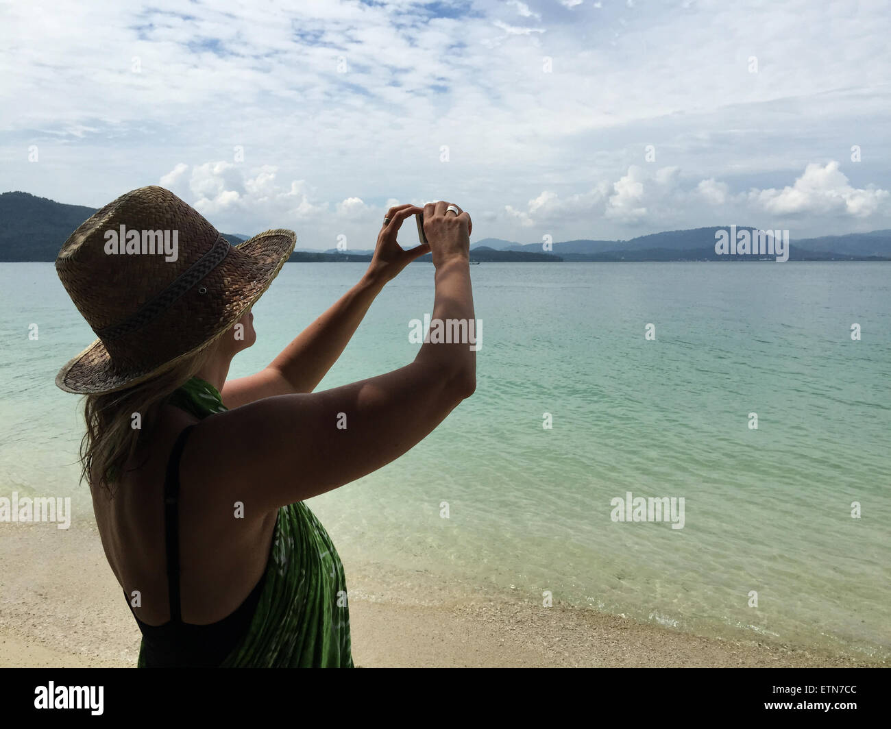 Femme sur la plage de la prise d'une photo Banque D'Images
