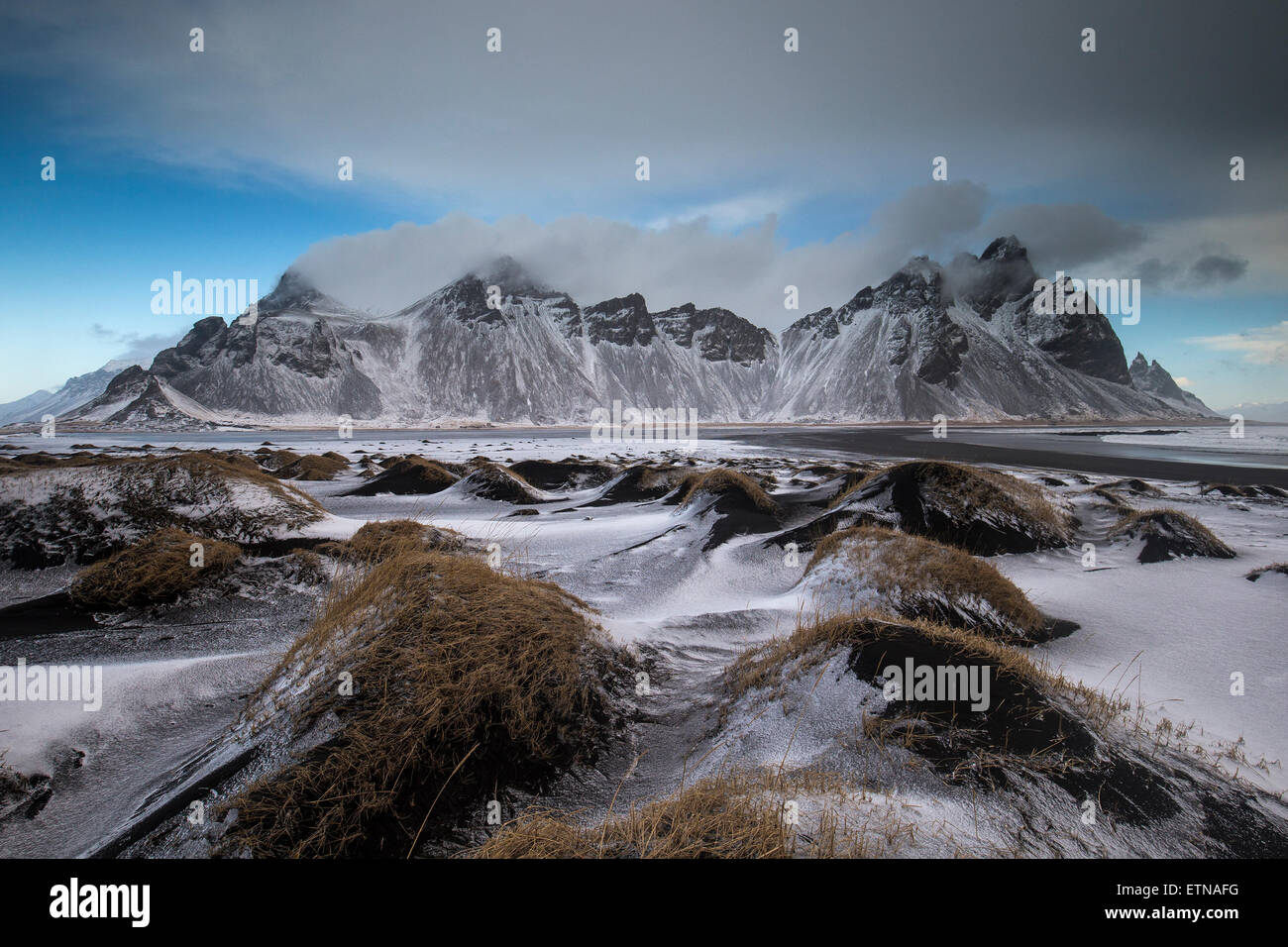 Montagnes couvertes de neige par plage de sable noir, l'Islande Banque D'Images