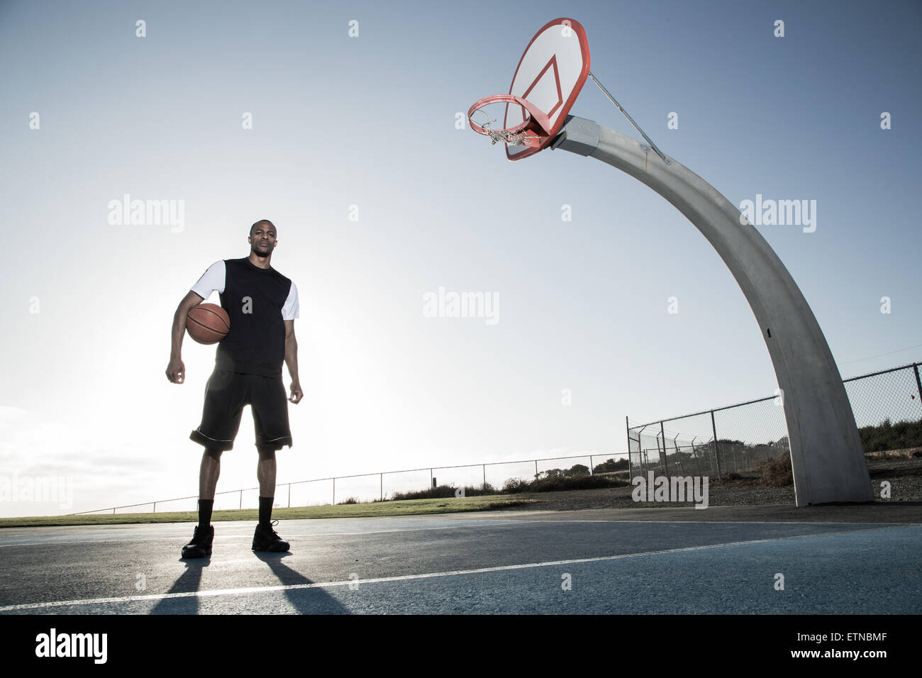 Portrait of a young man holding a basket-ball dans un parc, Los Angeles, Californie, USA Banque D'Images