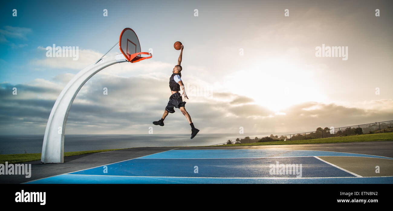 Jeune homme jouant au basket-ball dans un parc, Los Angeles, Californie, USA Banque D'Images