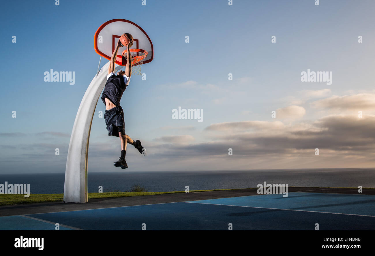 Jeune homme jouant au basket-ball dans un parc, Los Angeles, Californie, USA Banque D'Images