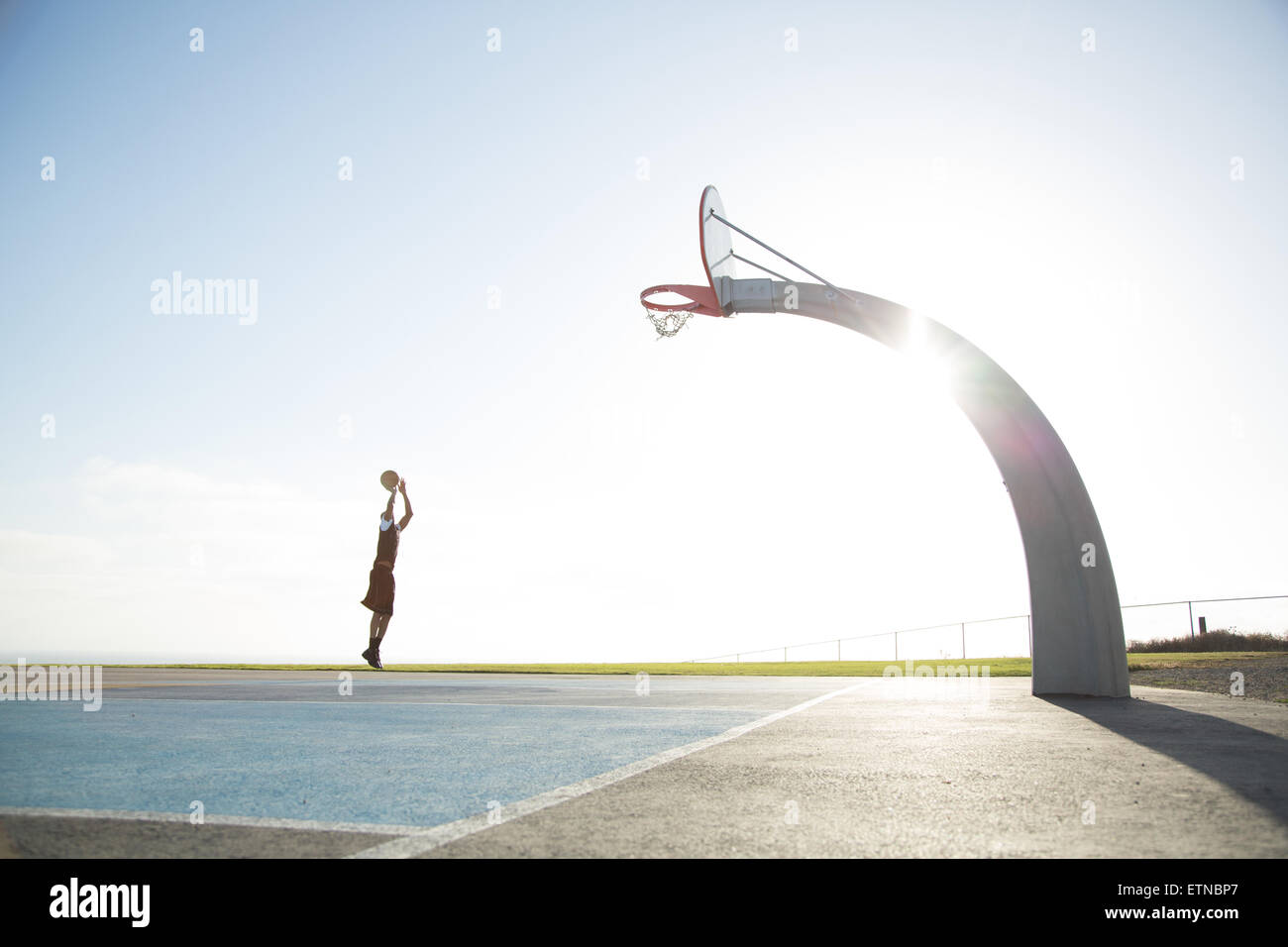 Jeune homme jouant au basket-ball dans un parc, Los Angeles, Californie, États-Unis Banque D'Images