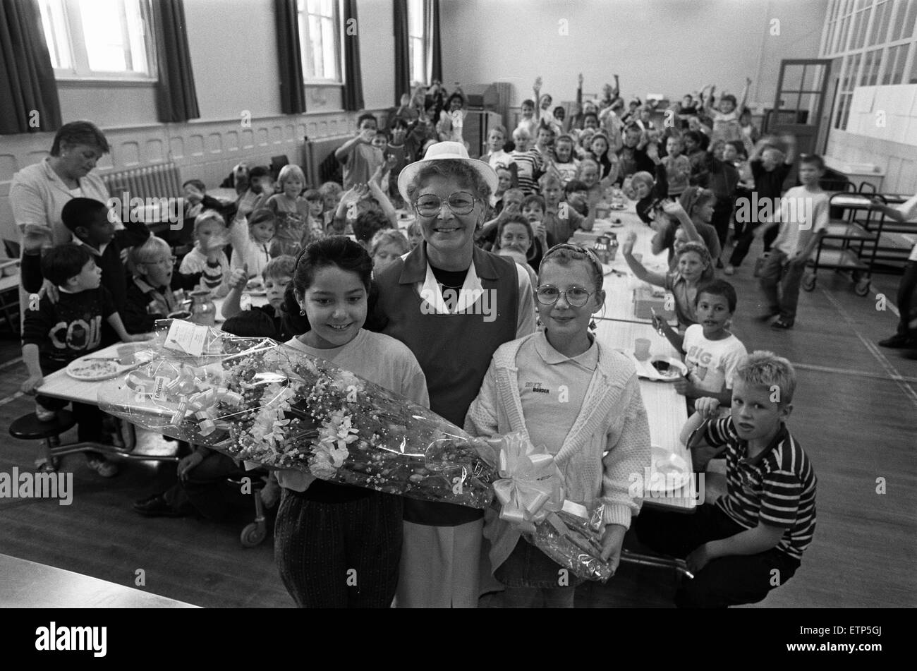 Le dîner-dame Mme Doreen Pounder a pris sa retraite après 28 ans à deux écoles de Huddersfield. Elle est photographiée de la réception d'un bouquet de fleurs à partir de Yasmeen Conway (à gauche) et Natasha Knutton Moldgreen, les élèves de junior, les nourrissons et l'école maternelle, où elle a spe Banque D'Images