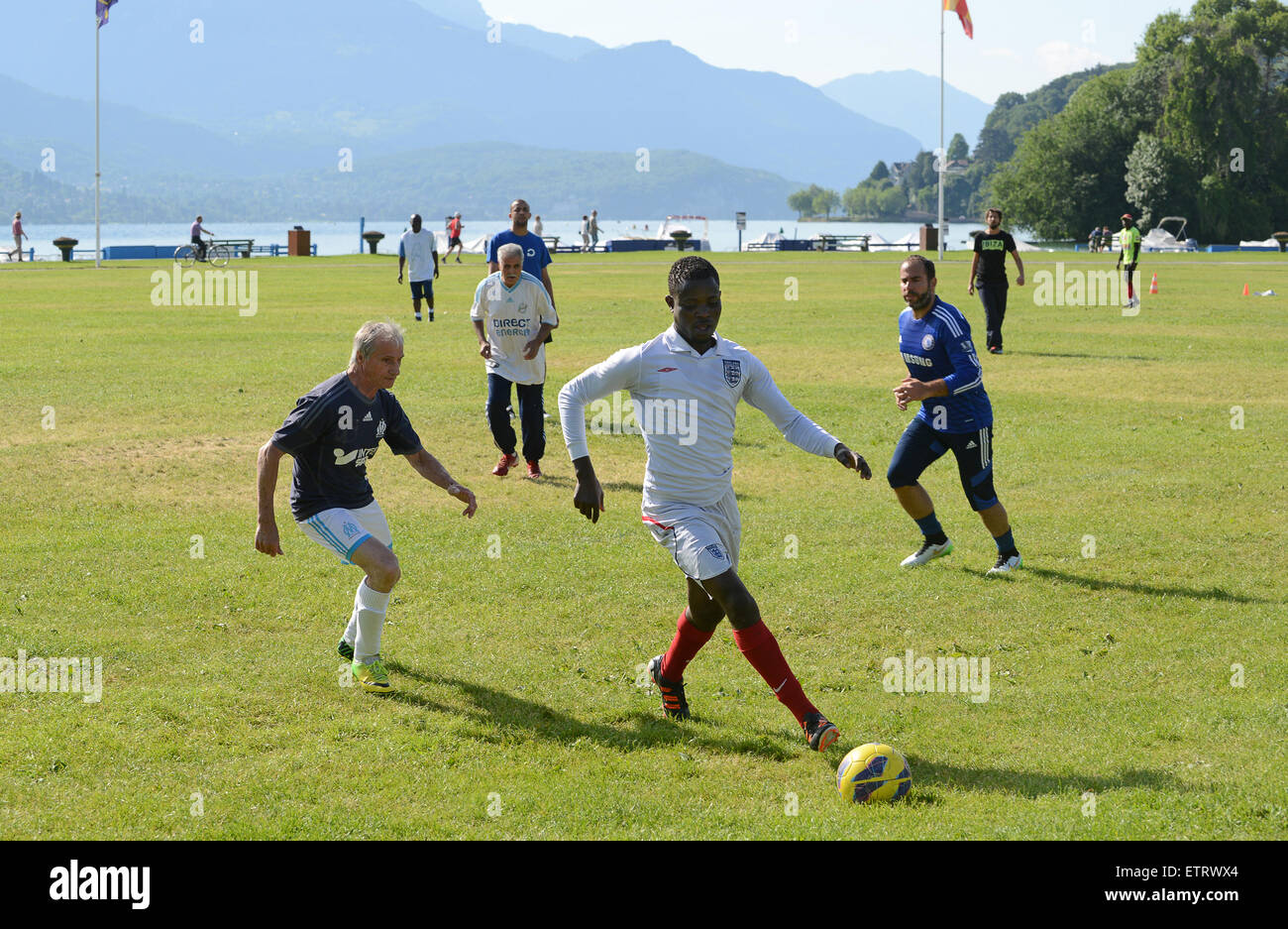 Footballeurs amateurs des hommes de tous âges jouent à un jeu impromptu dans le parc public d'Annecy en France. Des hommes jouent au football dans le parc Banque D'Images