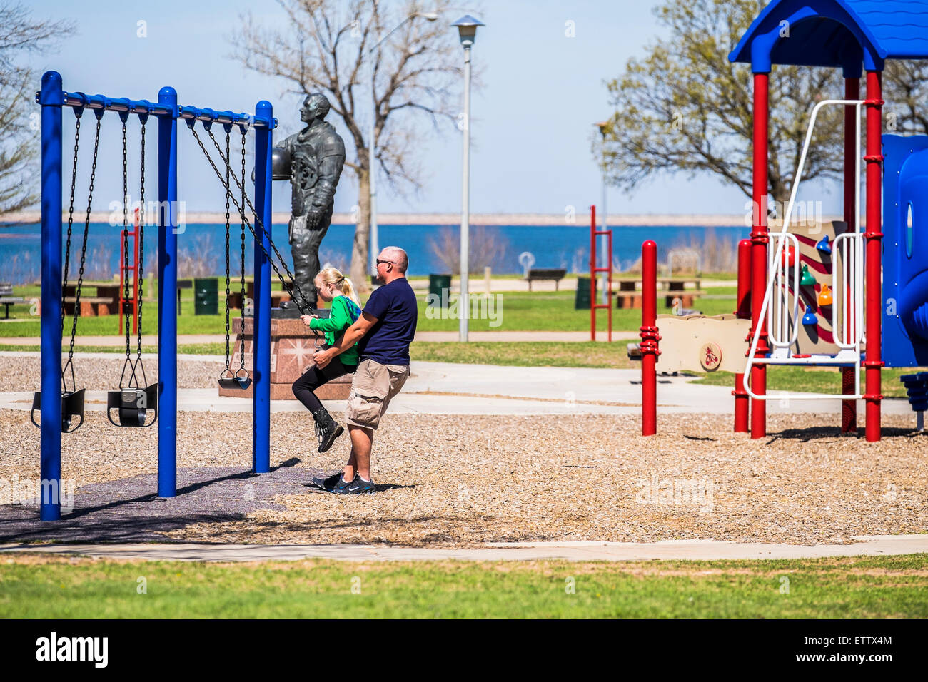 Un père de race blanche balançoires sa fille de 10 ans dans un jeu public à Oklahoma City, Oklahoma, USA. Banque D'Images