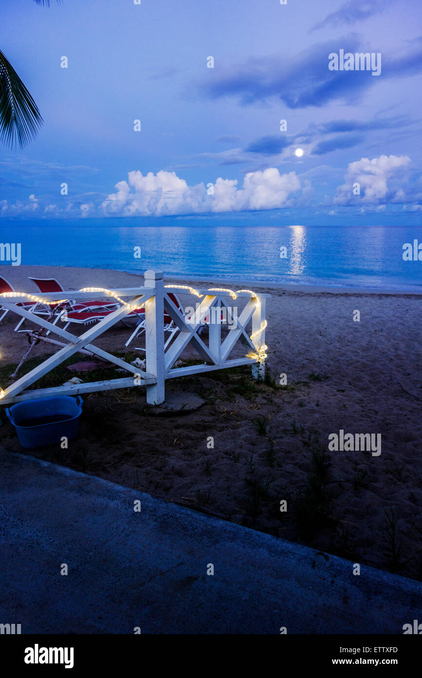 Une clôture peint en blanc avec des petites lumières enroulée autour d'elle d'améliorer un chemin à une plage des Caraïbes la nuit. Sainte Croix, Îles Vierges des États-Unis. USVI, U.S.V.I. Banque D'Images