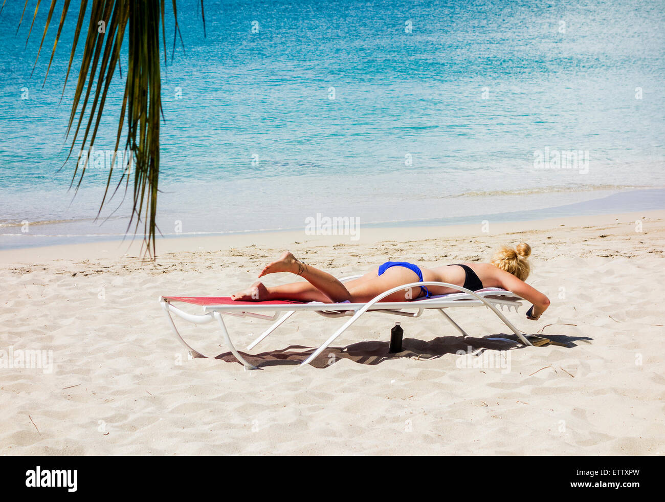 Portrait d'une femme blonde, des bains de soleil sur la plage à côté de la mer des Caraïbes. Sainte Croix, Îles Vierges des États-Unis. Banque D'Images