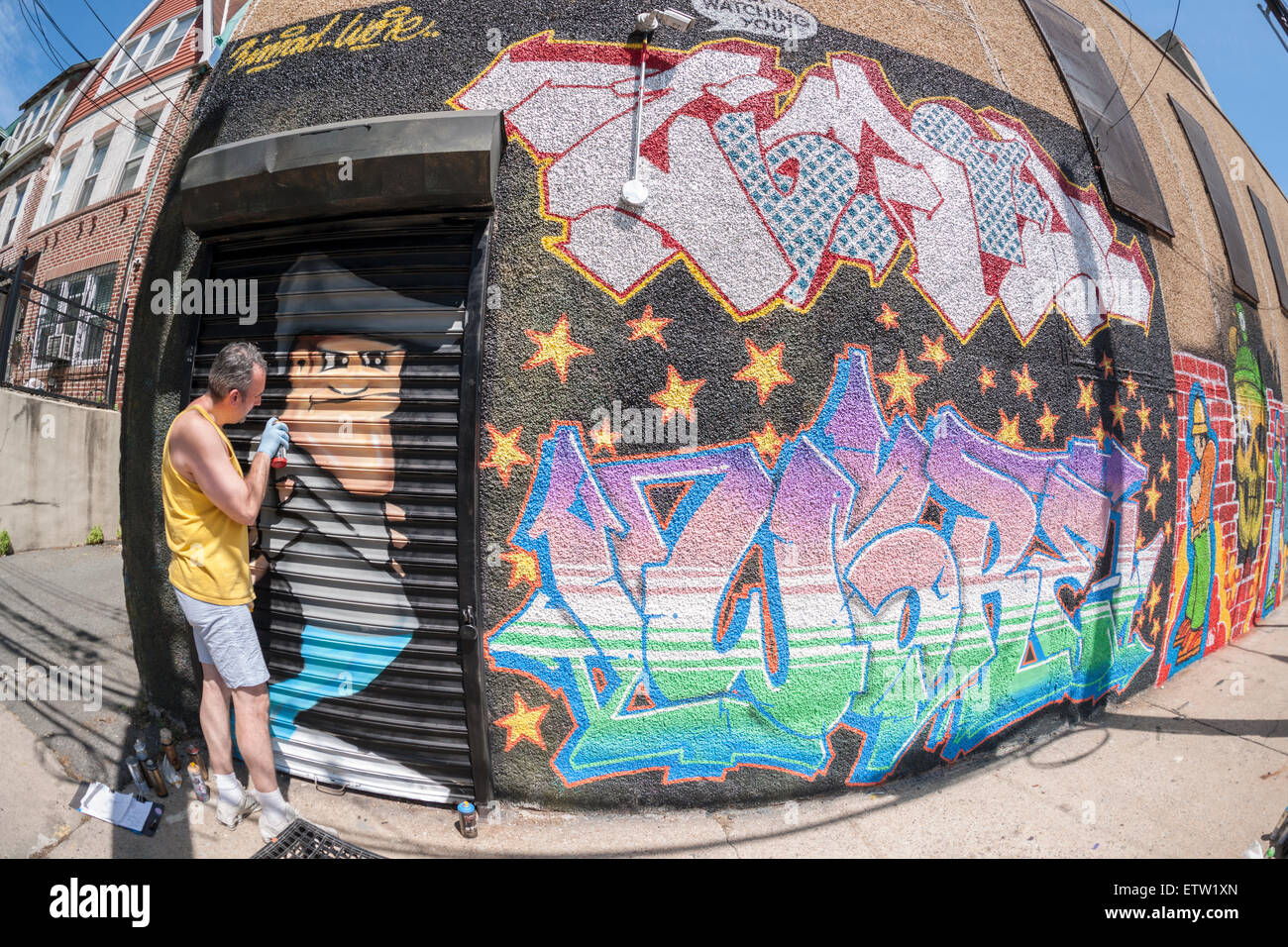 Artiste de rue Zimad portait au travail sur sa murale à la Cour Welling Projet mural dans le quartier du Queens Astoria à New York, le samedi, 13 juin, 2015. L'assemblée annuelle de l'événement quartier décore les murs de cette partie industrielle de Astoria. Le projet est financé par la foule et les nouveaux artistes de rue travaillent côte à côte avec des étoiles. (© Richard B. Levine) Banque D'Images