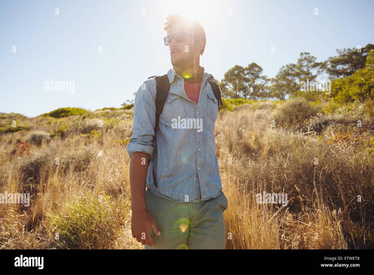 Image de jeune homme marche sur sentier de montagne à la route. Caucasian man en randonnée dans la nature sur une journée ensoleillée. Banque D'Images