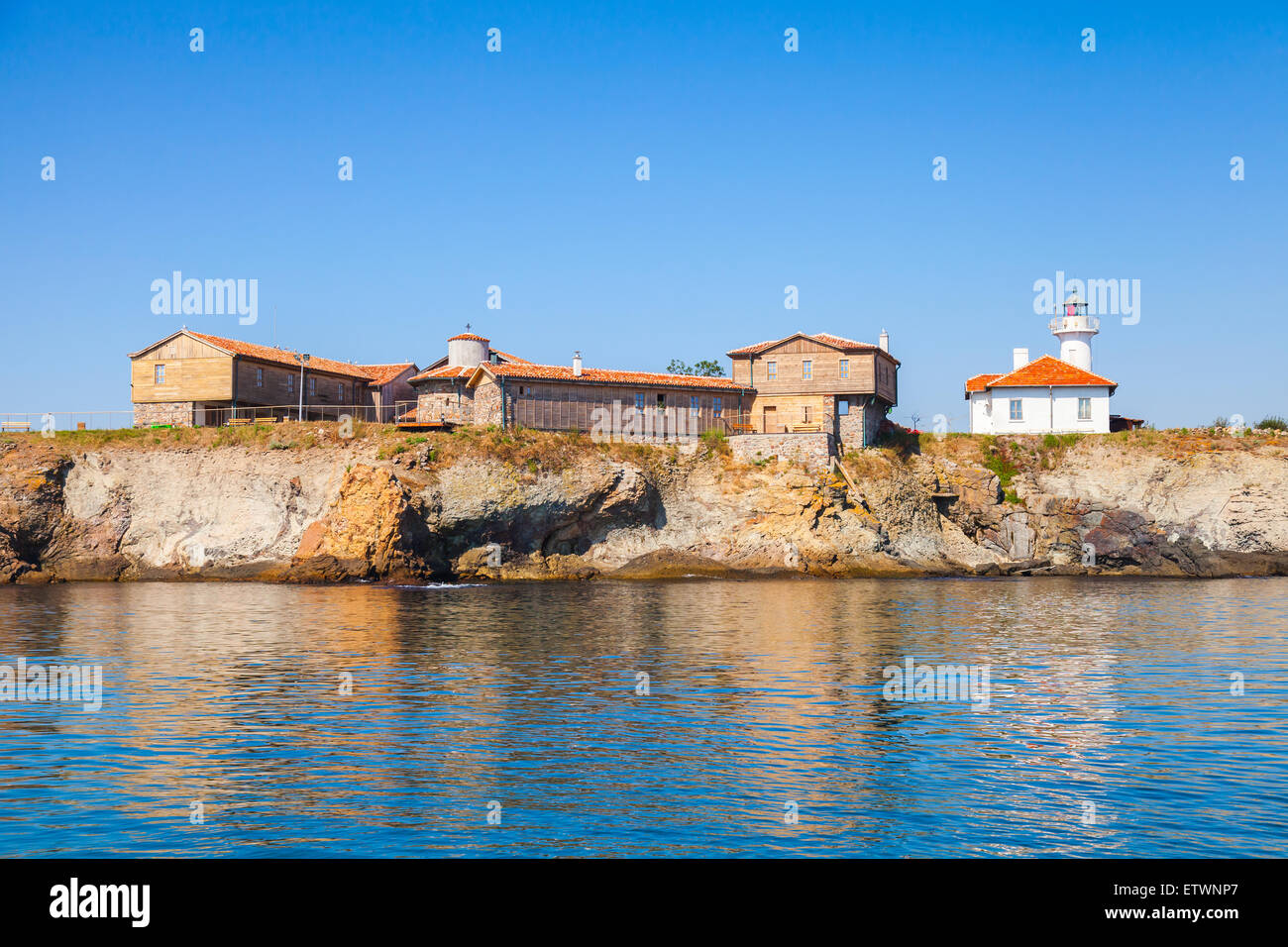 Phare blanc et de vieux bâtiments en bois sur l'île Ste Anastasie. Mer noire, Bulgarie Banque D'Images