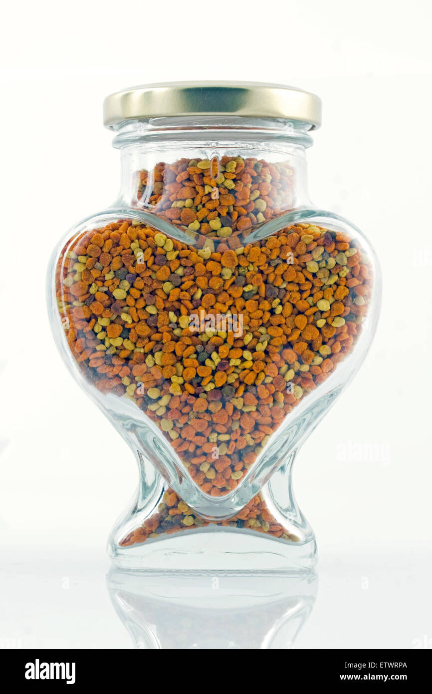 Couvercle en verre en forme de coeur fermé bocal rempli d'abeilles Apis séchées naturelles les grains de pollen frais bio Banque D'Images