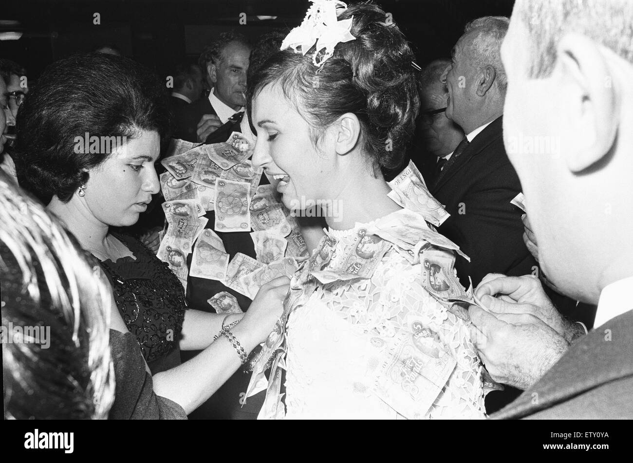 Elias Nicolas embrasse sa nouvelle épouse et Katerina à la suite de l'argent la danse à un mariage traditionnel grec. Où les dons d'argent de leurs clients sont épinglées sur les futurs mariés. 23 Septembre 1967 Banque D'Images