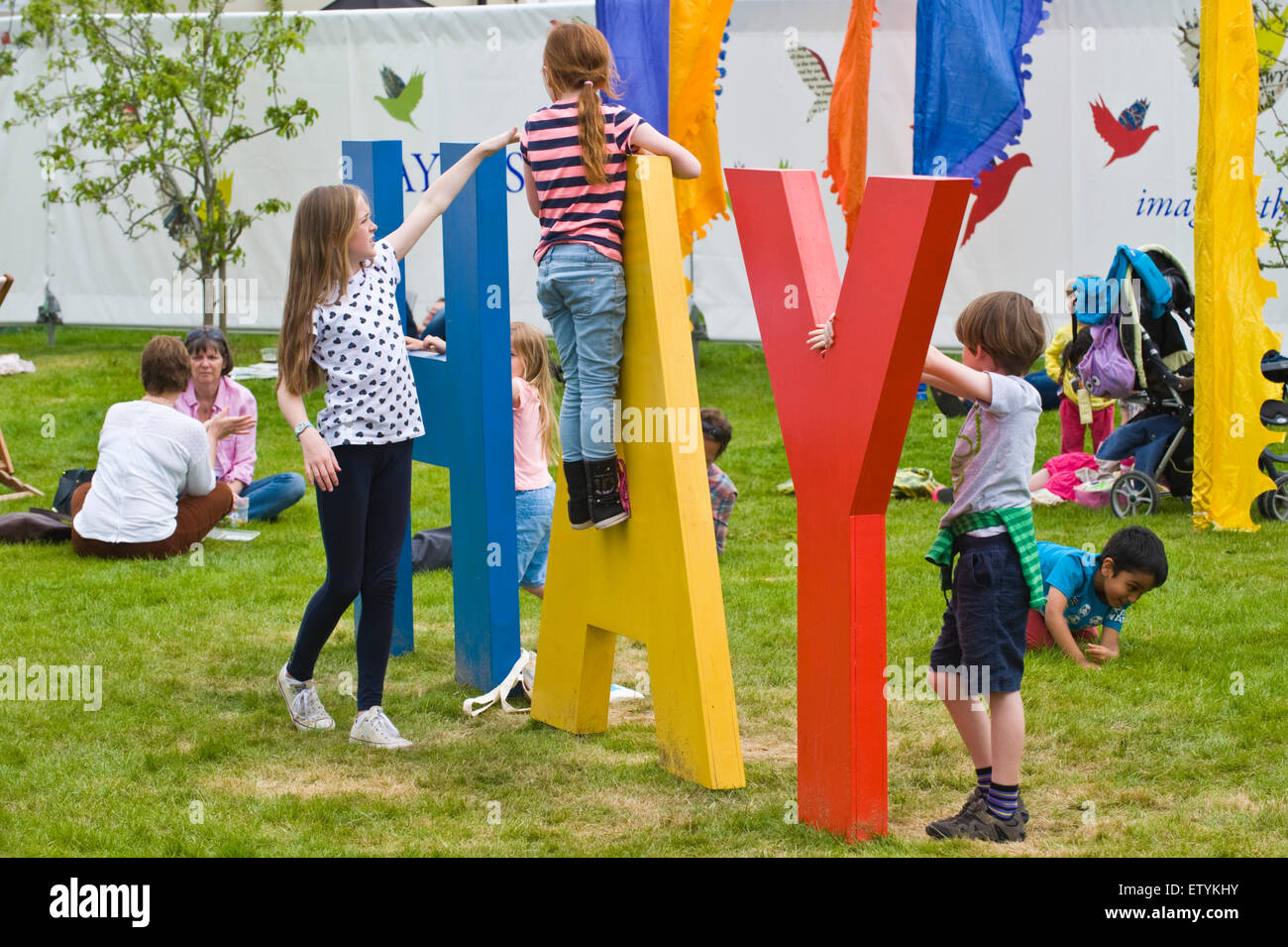 Les enfants jouent sur le FOIN géant signe sur pelouse à Hay Festival 2015 Banque D'Images
