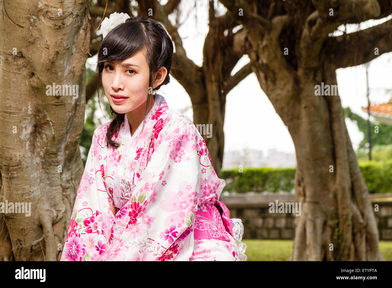 Femme Asiatique en kimono d'arbres dans le jardin Banque D'Images