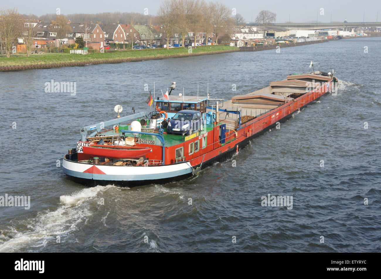 L'image représente un navire, ENI 04501350, naviguant sur l'Amsterdam-Rijnkanaal, une voie navigable clé des pays-Bas. Cette scène présente différents types de navires, y compris des pétroliers, des porte-conteneurs et des barges, illustrant les activités commerciales occupées sur le canal, vitales pour le commerce et le transport. Banque D'Images