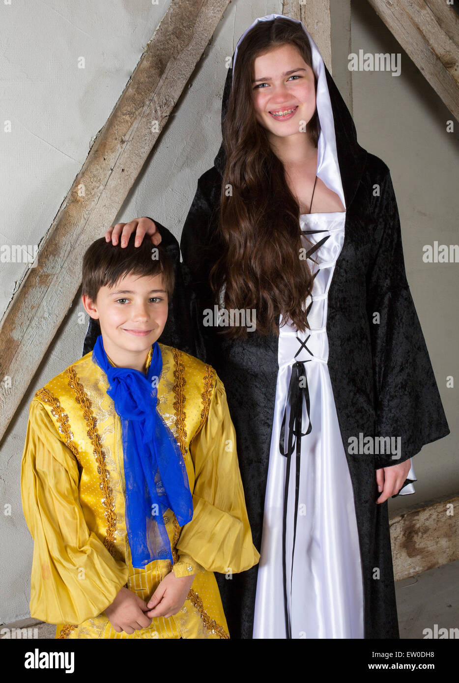 Jeune fille à bretelles habillée en princesse et petit garçon habillé en prince Banque D'Images