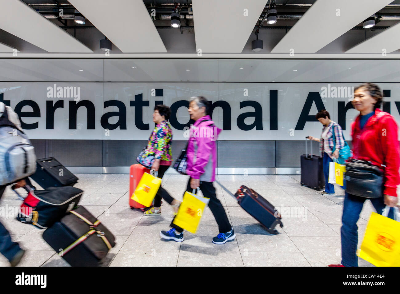 Les touristes arrivant à l'aéroport de Heathrow, Londres, Angleterre Banque D'Images