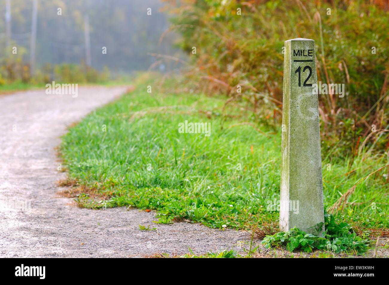 Stone mile marker sur un sentier de randonnée et de jogging Banque D'Images