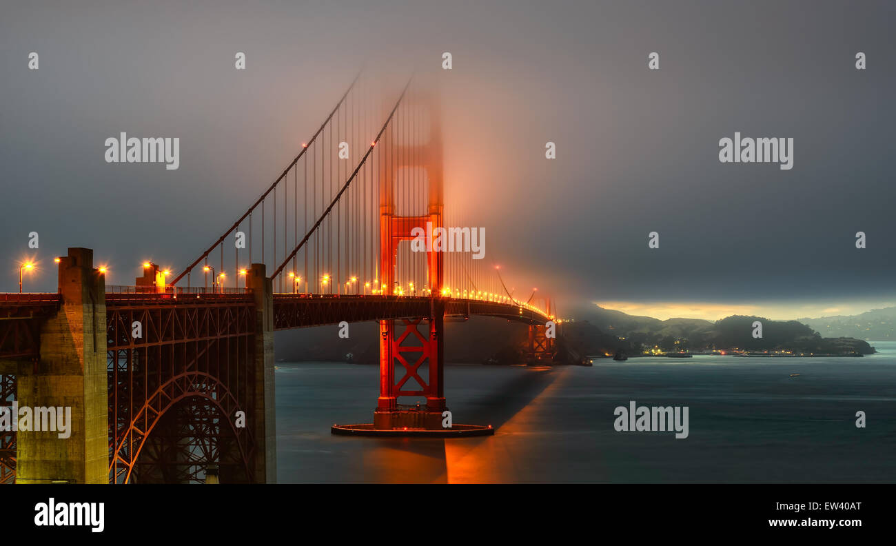 Le Golden Gate Bridge foggy éclairement sur le coucher du soleil Banque D'Images