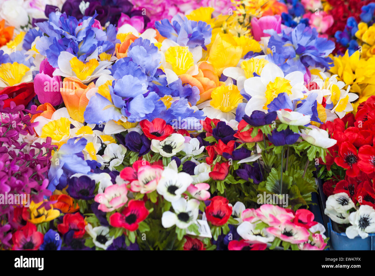Fleurs artificielles en plastique à vendre sur le stand du marché à Dorchester, Dorset, Royaume-Uni en juin Banque D'Images