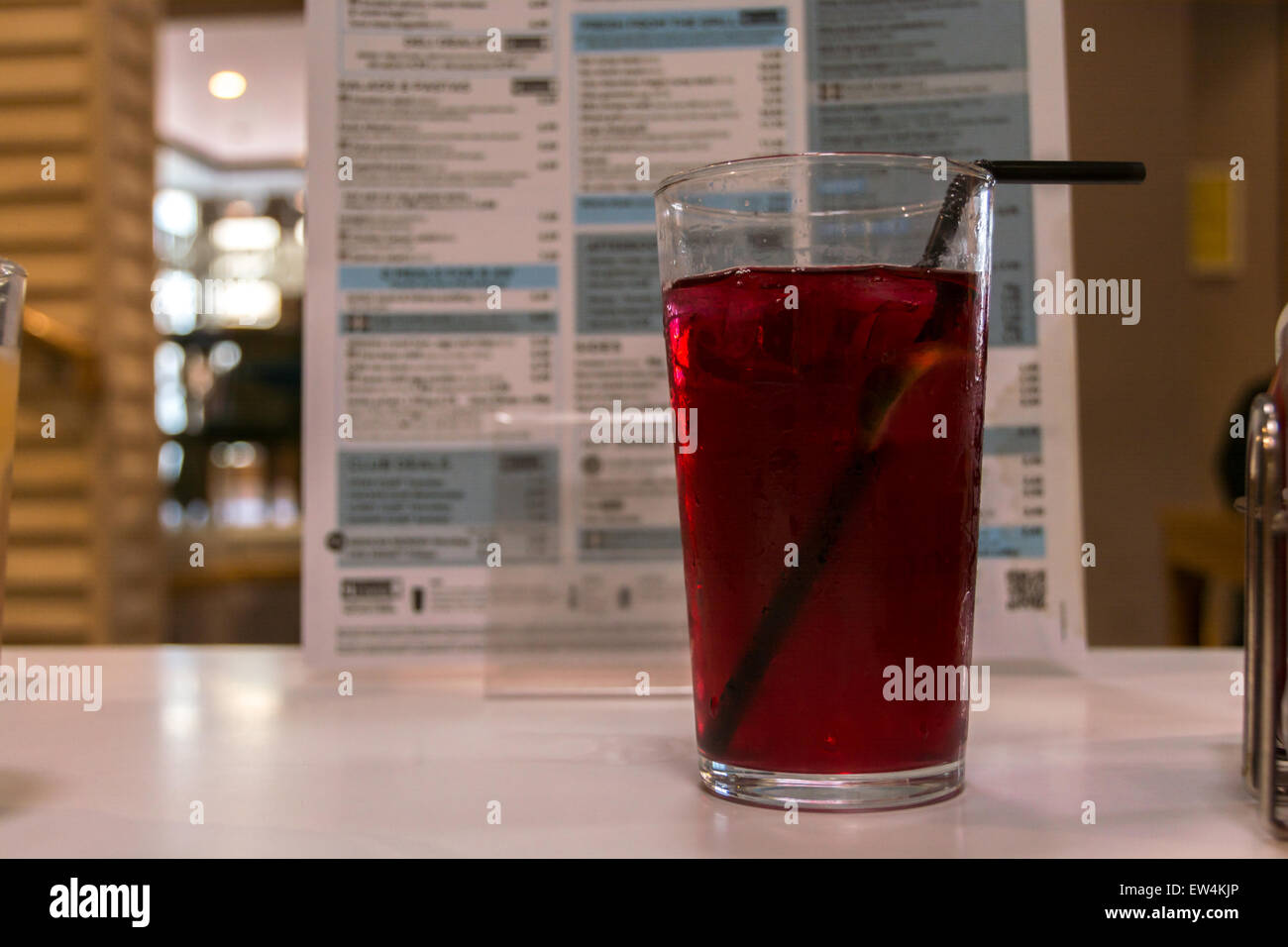 Verre rouge sur table de restaurant avec menu en arrière-plan à grande ouverture Banque D'Images