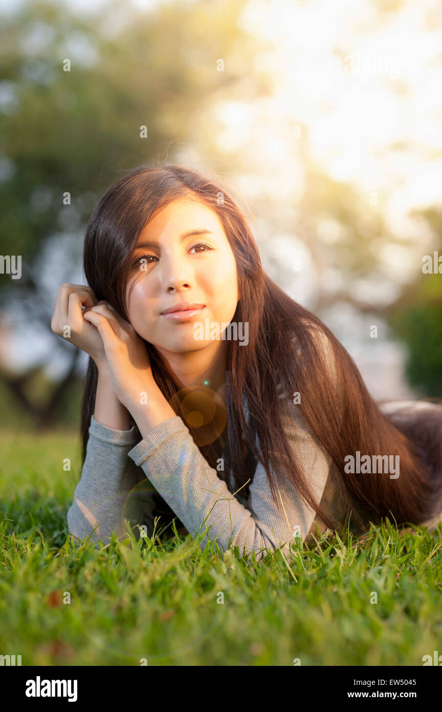 Jeune femme allongée sur l'avant et à l'écart avec le sourire Banque D'Images