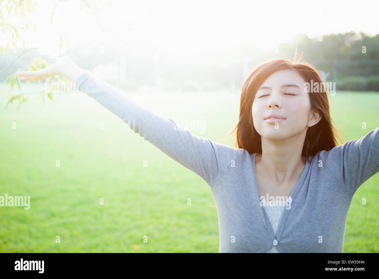 Jeune femme fermeture yeux with arms outstretched Banque D'Images