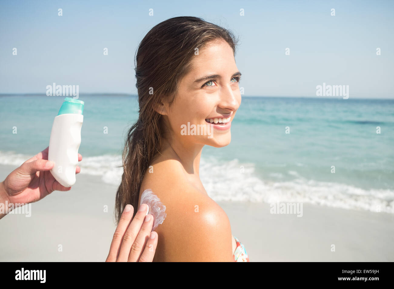Man putting crème solaire sur sa petite amie Banque D'Images