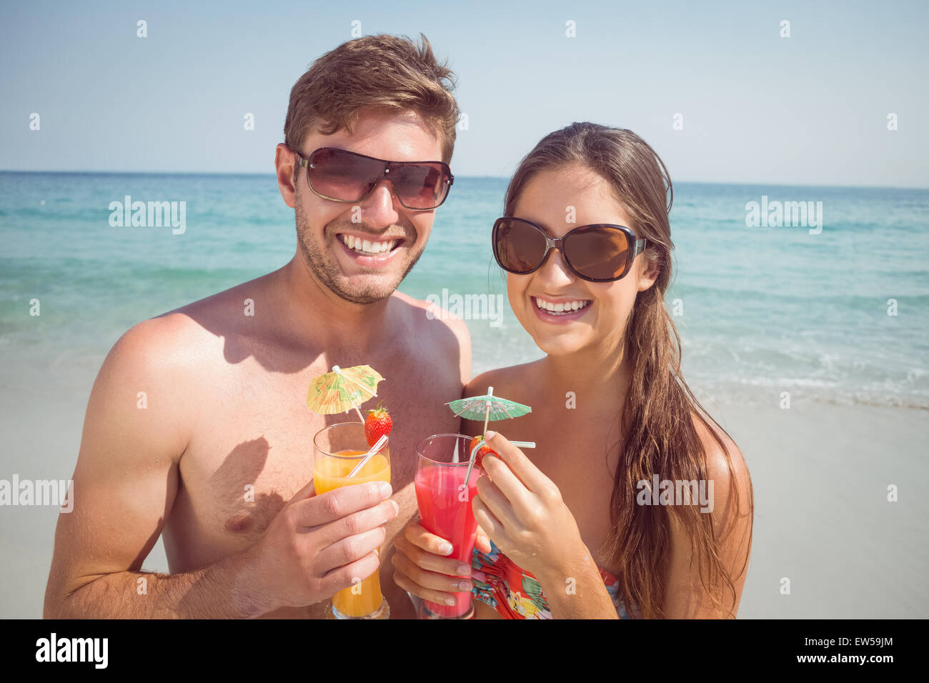 Heureux couple smiling at camera with cocktail Banque D'Images