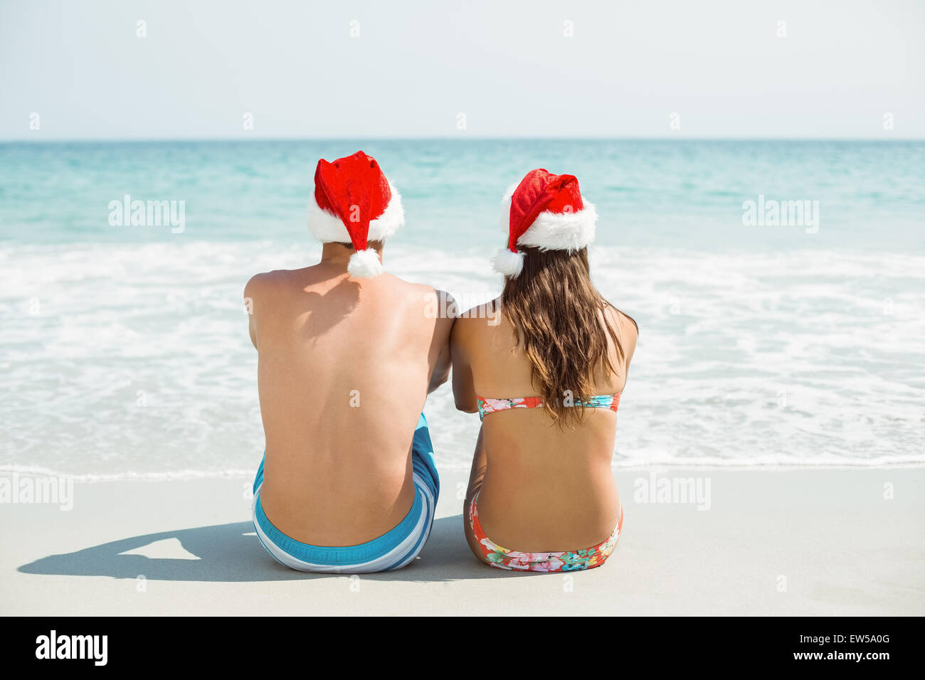 Voir l'usure du couple looking at sea with santa hat Banque D'Images