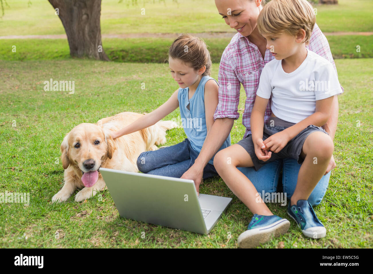 Famille heureuse avec leur chien using laptop Banque D'Images