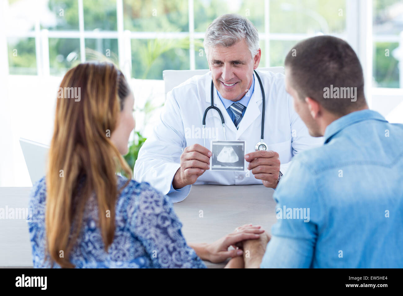 Smiling doctor showing échographie pour le couple Banque D'Images