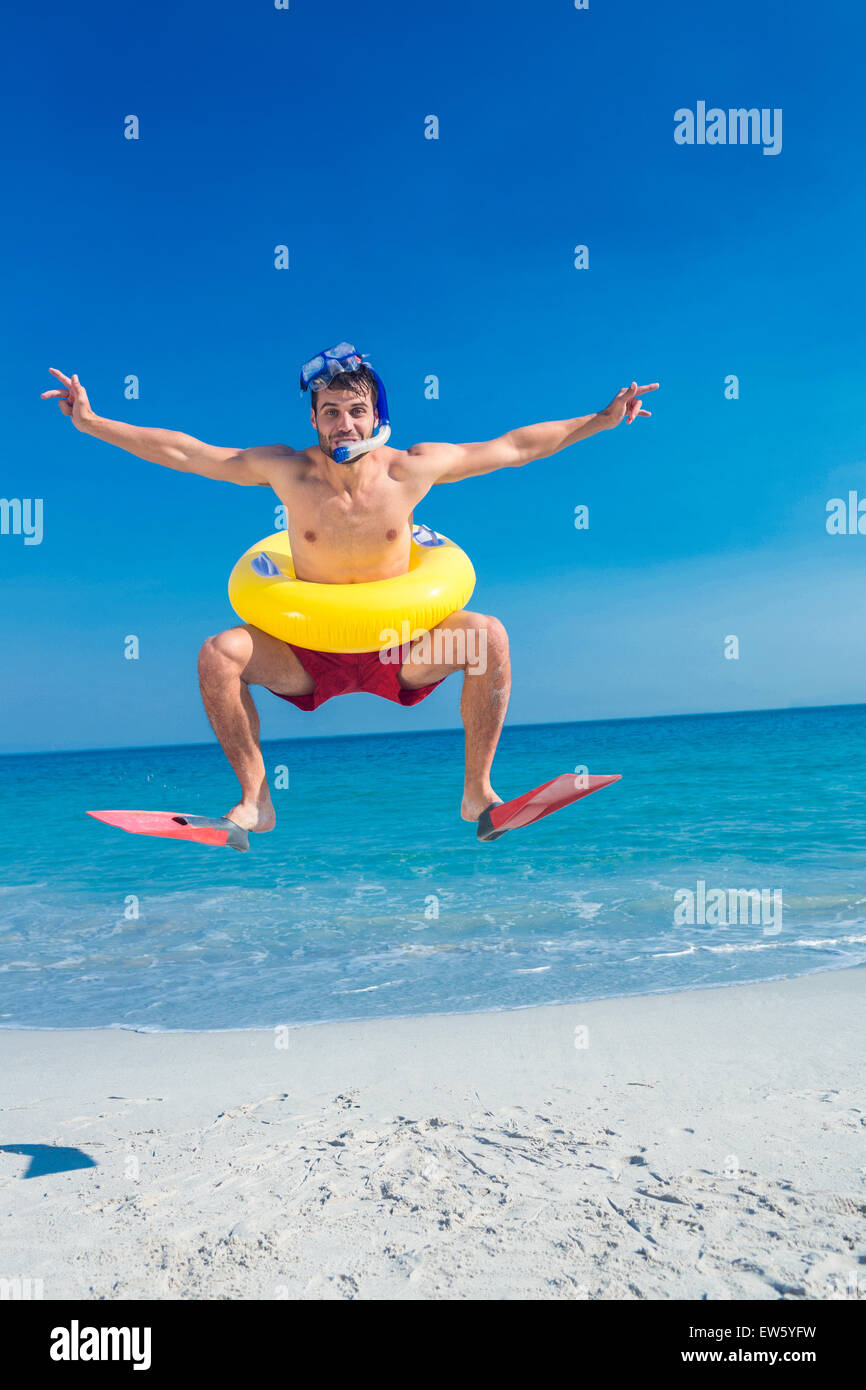 Homme portant des palmes et des anneaux en caoutchouc à la plage Banque D'Images