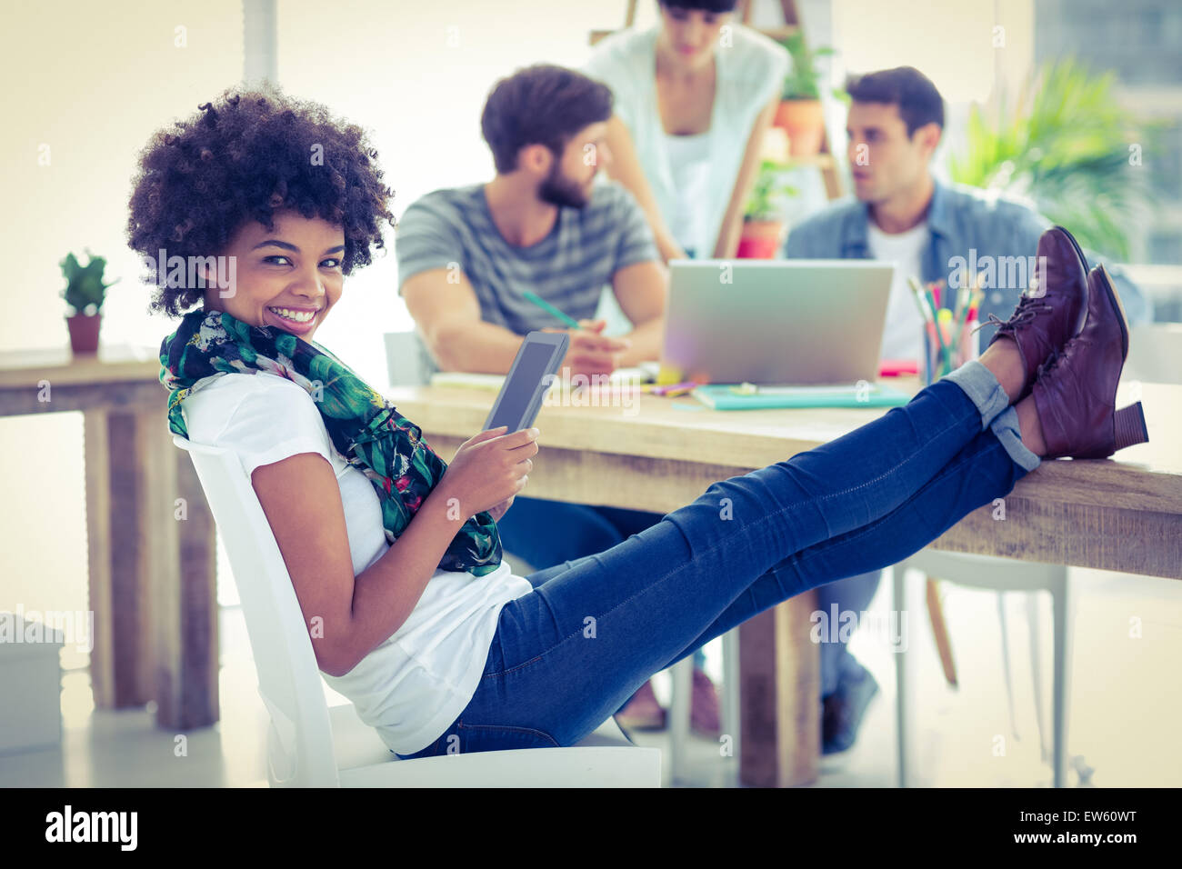 Jeune femme avec les pieds sur la table Banque D'Images
