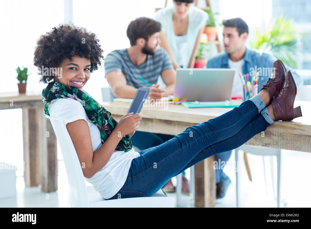 Jeune femme avec les pieds sur la table Banque D'Images