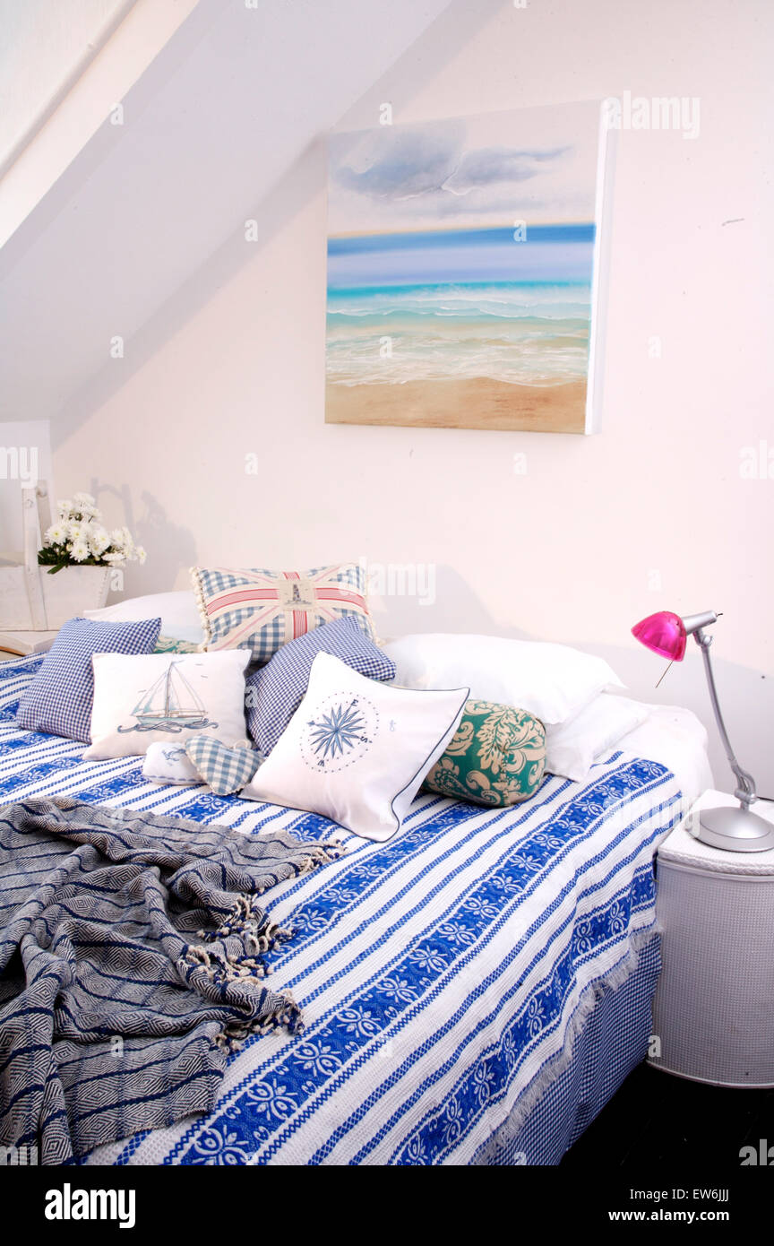 Seascape peinture sur mur au-dessus de lit avec couvre-lit bleu +blanc à  rayures et coussins à motifs Photo Stock - Alamy
