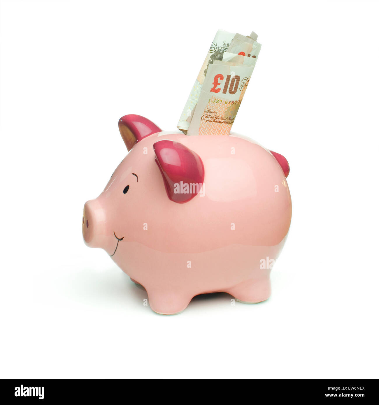Pink piggy bank avec £10 notes, isolé sur un fond blanc. Banque D'Images
