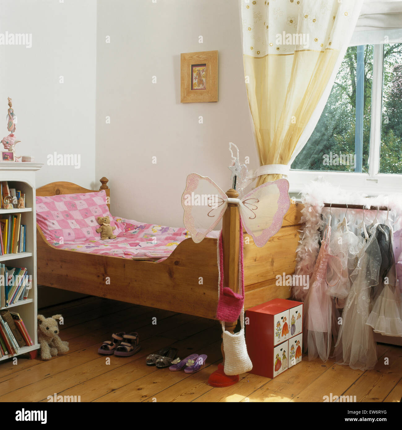 Linge rose sur son lit en pin girl's bedroom avec rideaux crème sur la fenêtre Banque D'Images