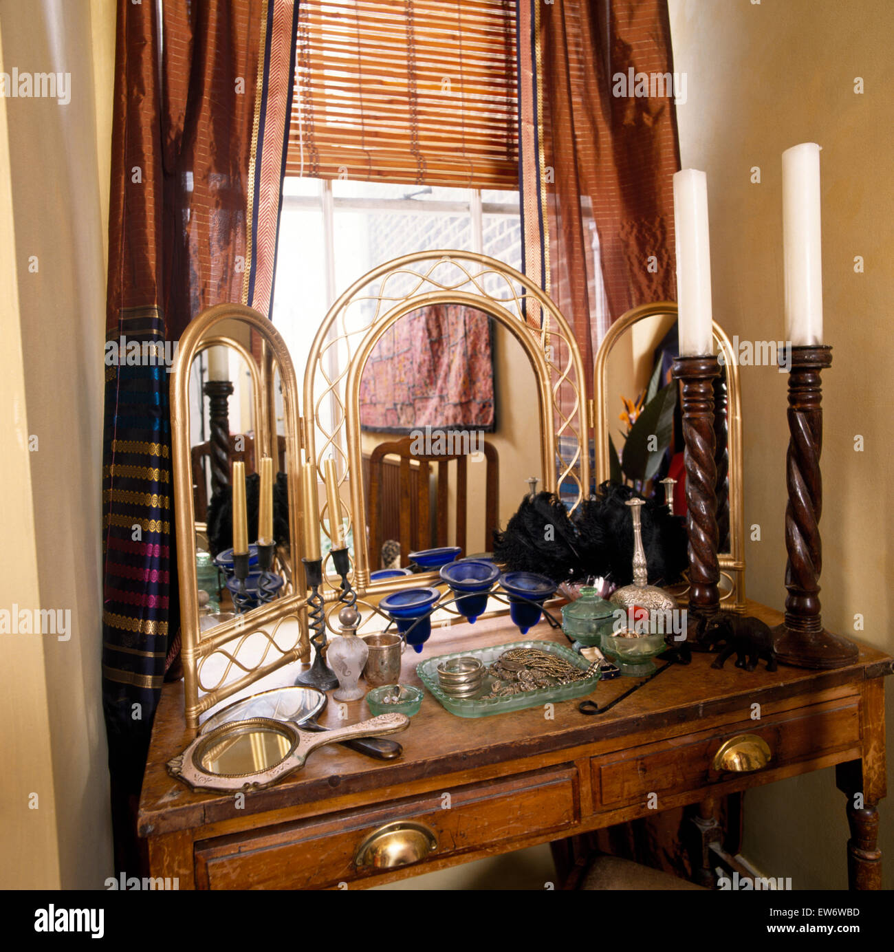 Grands chandeliers en bois et bambou doré miroir triple sur une coiffeuse dans la chambre à coucher de style économique Banque D'Images