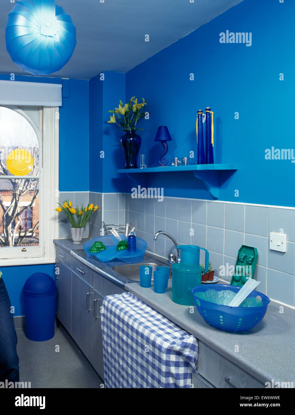 Années 90 bleu lumineux avec cuisine de style économique unités peints argent Banque D'Images