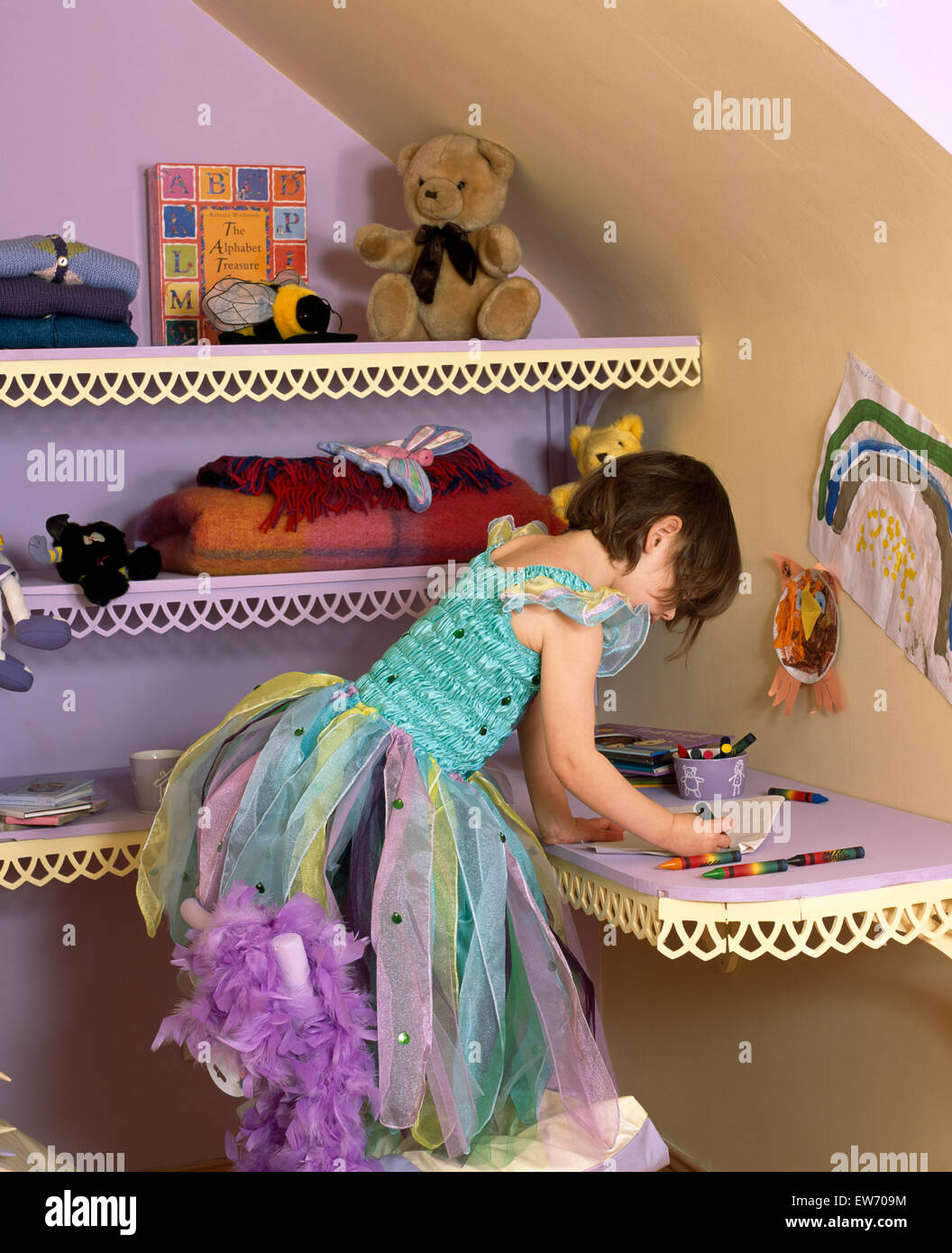 Petite fille portant un costume de fée et s'appuyant sur un plateau festonné Banque D'Images