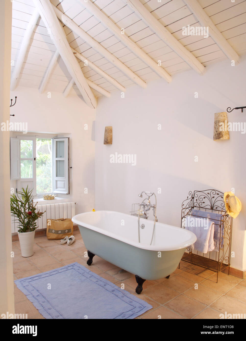Baignoire à l'espagnol en blanc laqué blanc salle de bains avec plafond à  poutres apparentes et carrelage en pierre Photo Stock - Alamy
