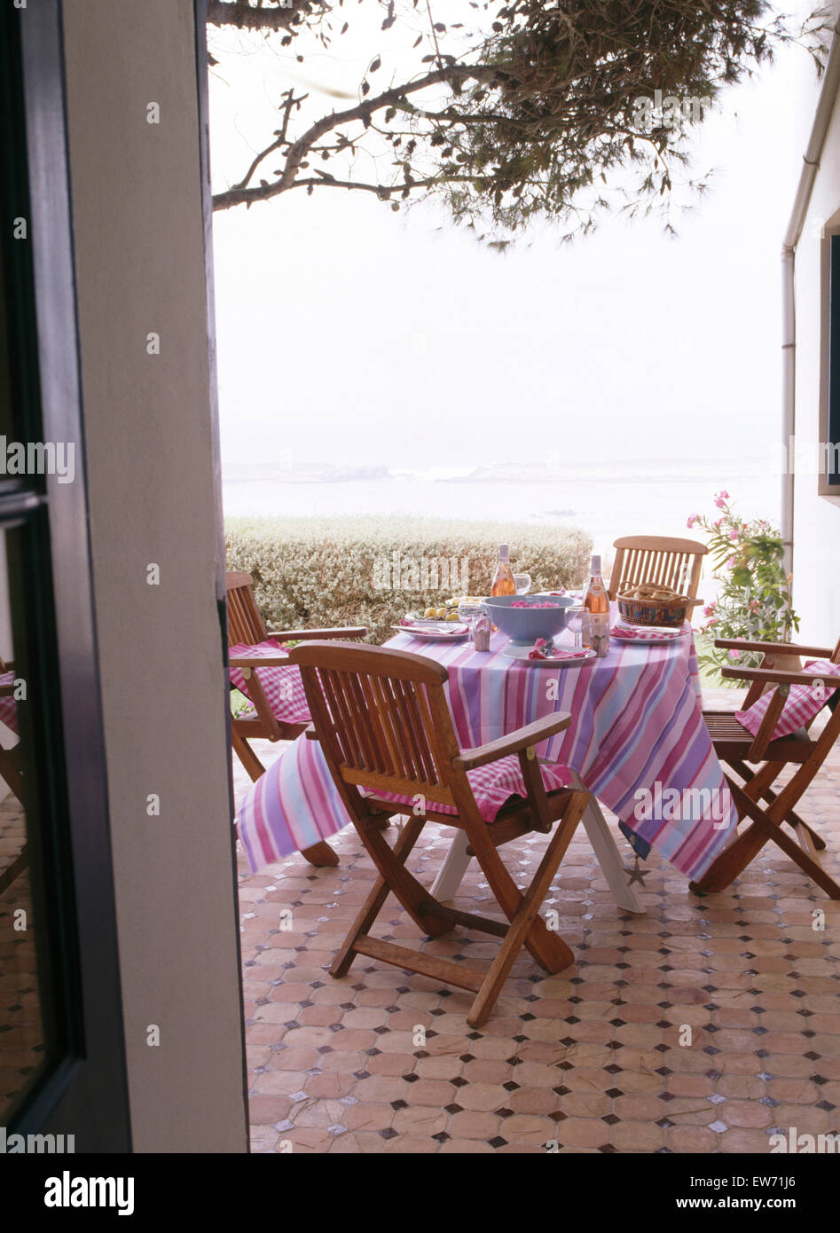 À table avec chaises en bois en tissu rayé rose sur la terrasse de la villa à Corfou avec vue sur la mer Banque D'Images
