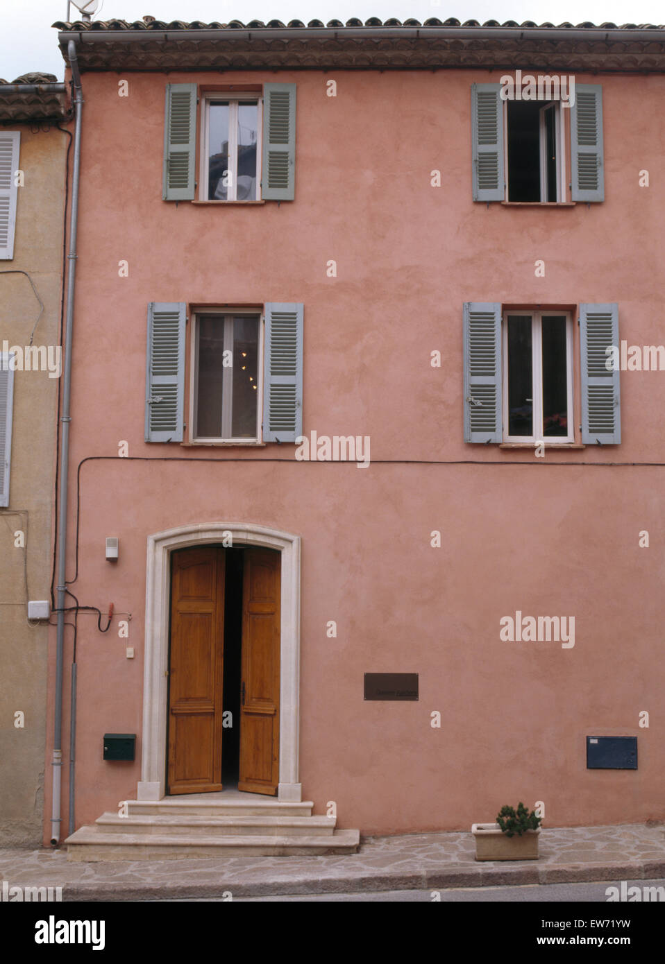 Rose extérieur de maison de village avec volets peints en bleu dans le sud de la France Banque D'Images