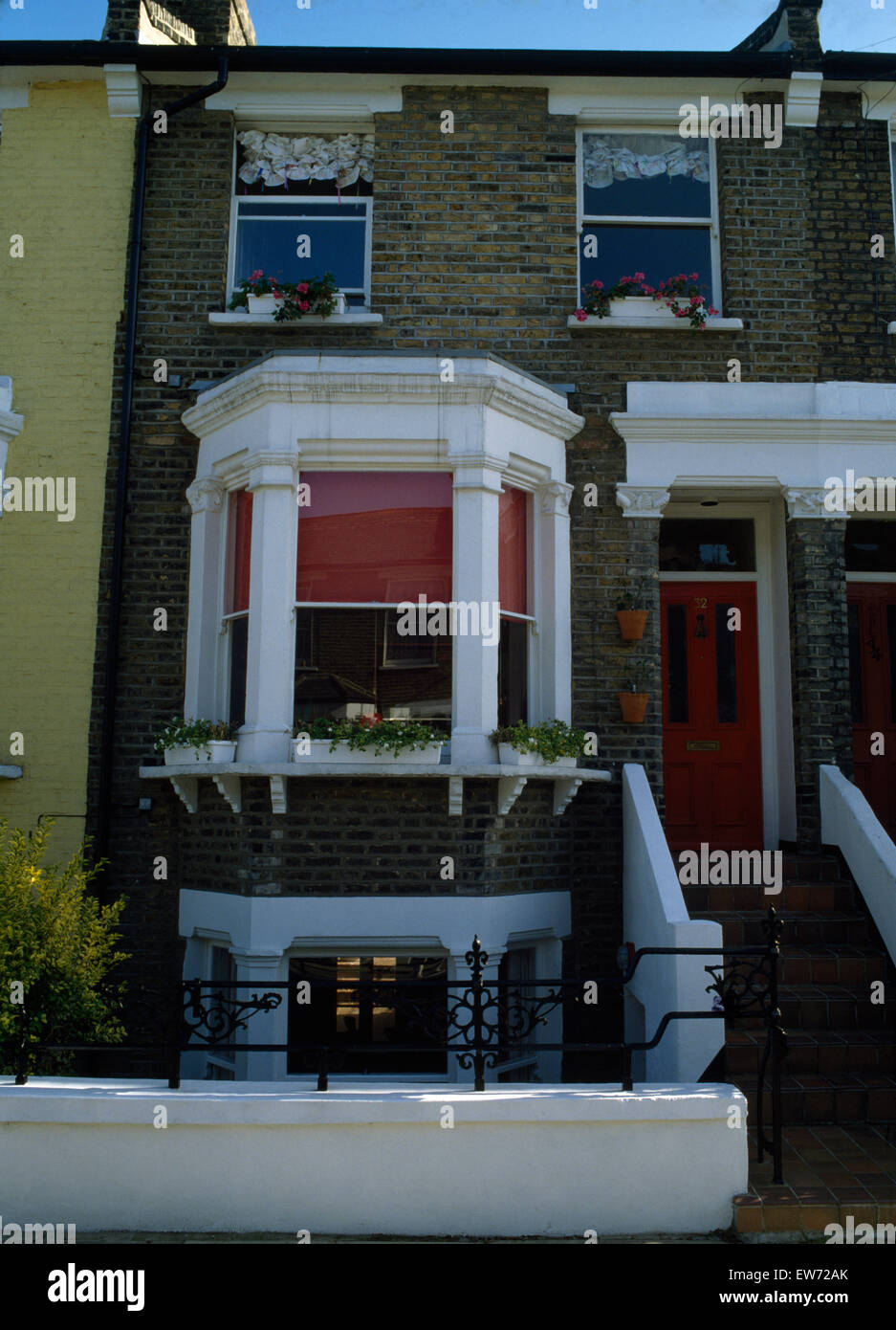 Extérieur de maison victorienne avec terrasse avec baie vitrée derrière aveugle rouge Banque D'Images