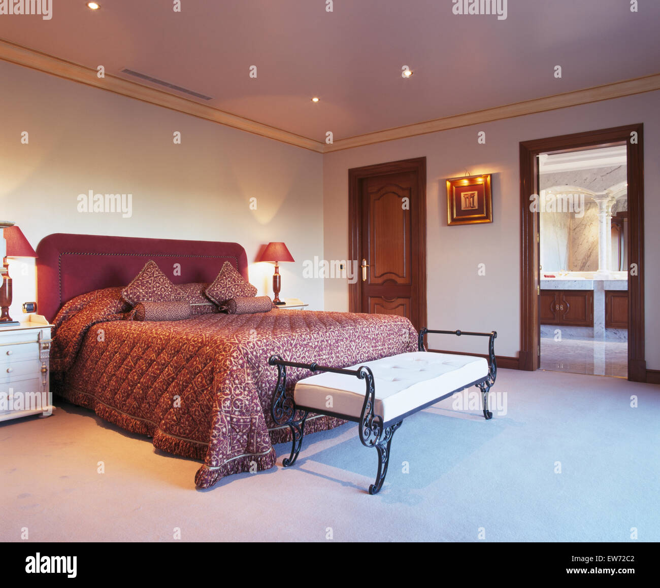 Courtepointe rose profond et de coussins sur le lit en espagnol chambre  avec tapis blanc et tabouret en fer forgé Photo Stock - Alamy