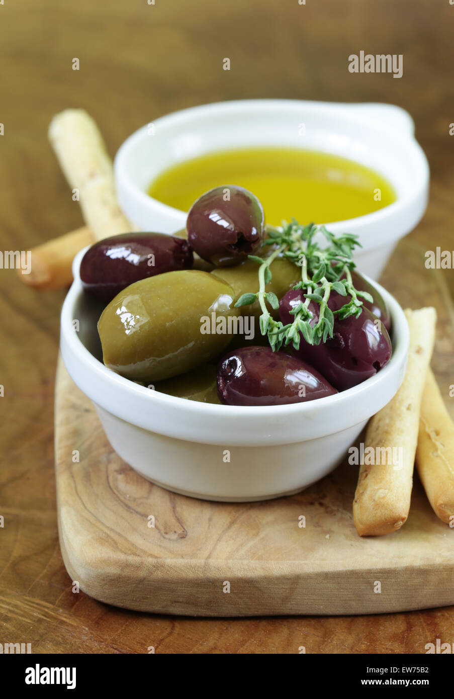 Olives noires et vertes dans l'huile avec des herbes Banque D'Images