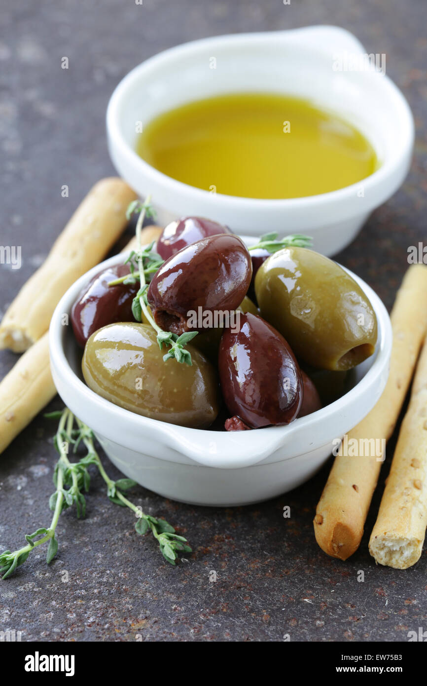 Olives noires et vertes dans l'huile avec des herbes Banque D'Images