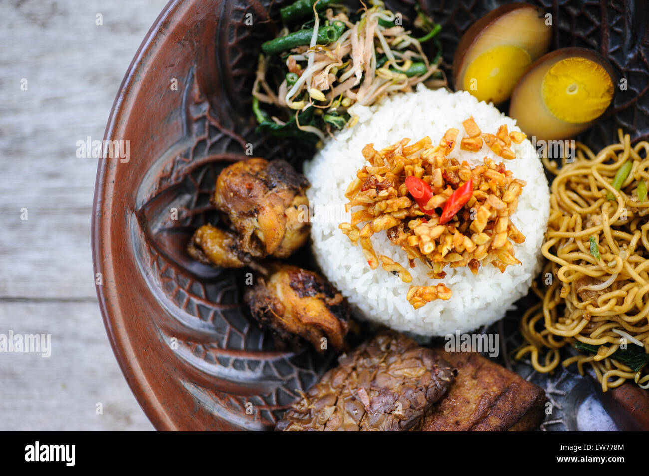 Nasi campur indonésien avec du poulet frit, des nouilles, des œufs, le tempeh et les légumes. Banque D'Images