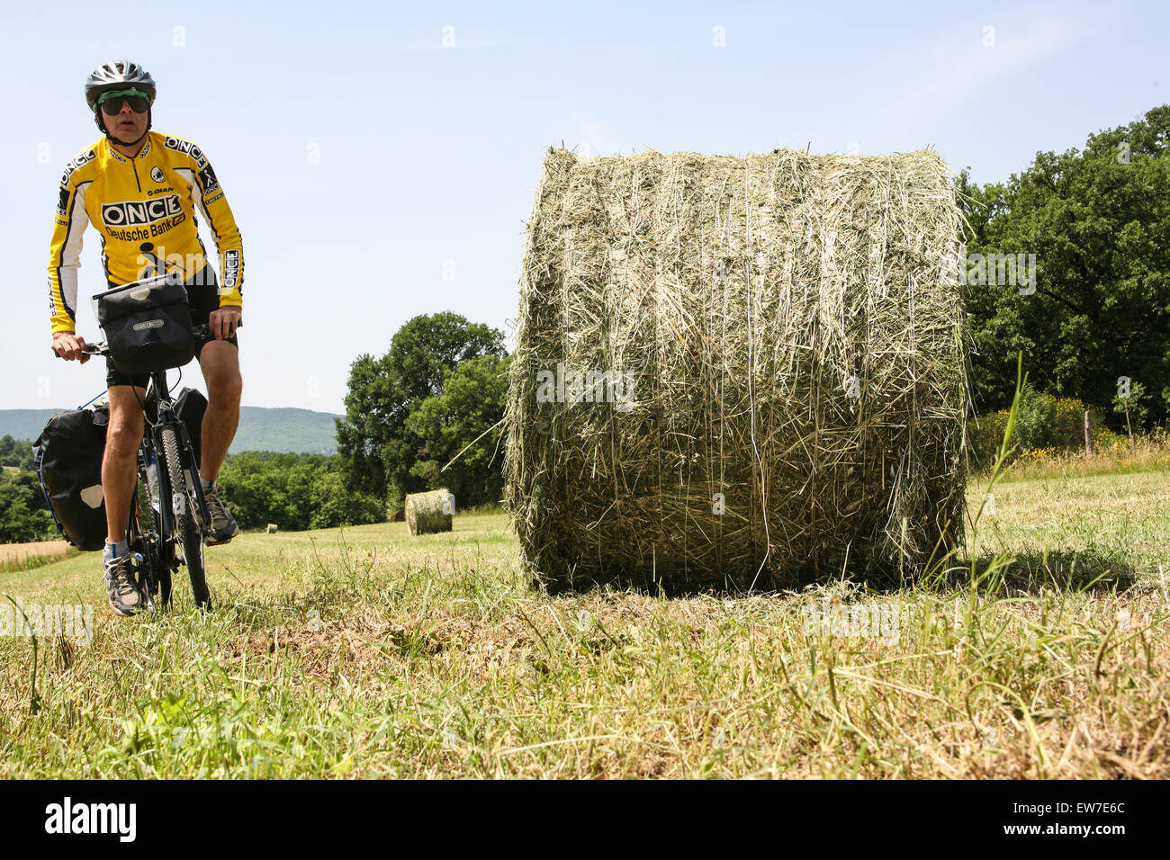 Moi, un touriste anglais, faire du vélo à travers les champs de blé sur un  vélo de randonnée chargé dans la campagne près de Sienne en Toscane.  L'Italie. De juin. Parution du